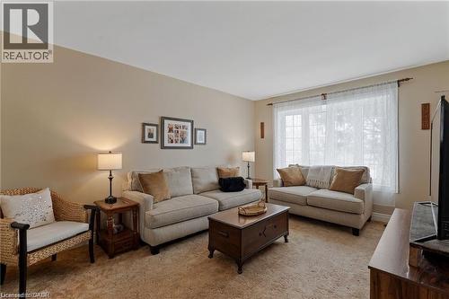 Spacious living area featuring neutral-toned walls, a large window, and carpet flooring - 2 Mill Street E, York, ON 