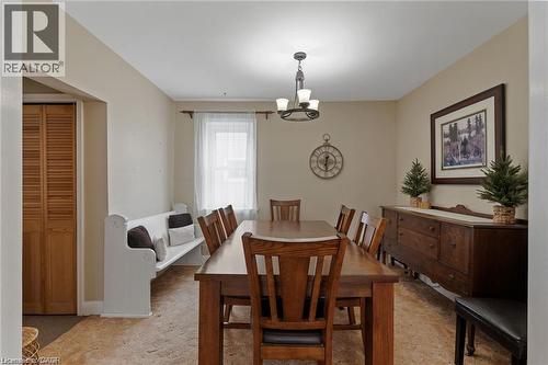 Dining area featuring an overhead chandelier, a single window with curtain rod, neutral wall paint, and wood-finish flooring - 2 Mill Street E, York, ON 