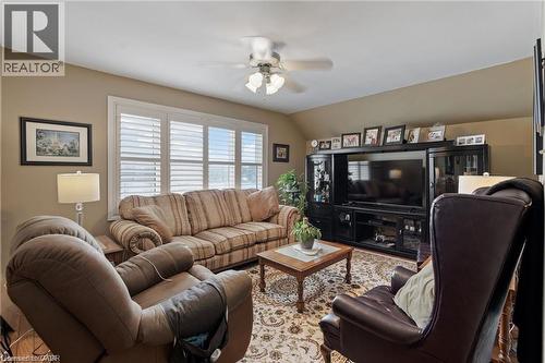 Living area featuring a multi-paned window with white louvered shutters, a ceiling fan with integrated lighting, and neutral wall tones - 2 Mill Street E, York, ON 