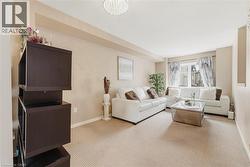 Living area with neutral tone wall color and light-colored carpet flooring - 