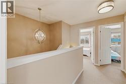 Upper-level hallway with light-colored carpeting and neutral wall tones - 