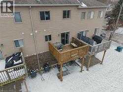Rear exterior showcasing two elevated wood decks with railings and ground-level patios - 