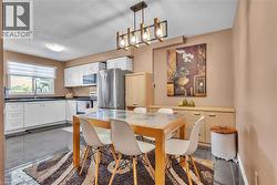 Open concept kitchen and dining area featuring dark tile flooring - 