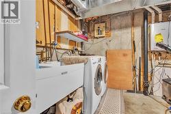 Laundry area featuring a utility sink, a front-loading washing machine, and a tankless water heater - 