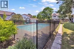 Fenced in-ground swimming pool with surrounding concrete patio - 