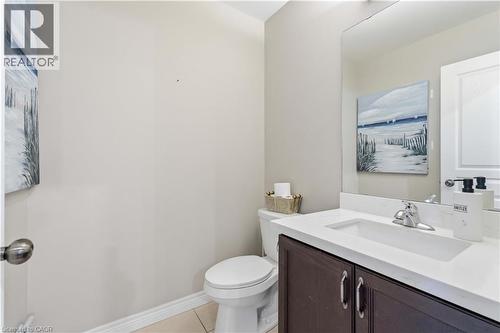 Bathroom featuring a dark wood-finish vanity with a white countertop, an integrated sink, and a chrome faucet - 212 Chartwell Circle, Hamilton, ON 