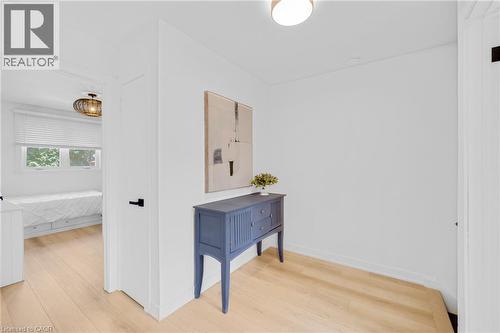 Hallway featuring wood-finish flooring, white walls, and a recessed ceiling light - 5275 Banting Court, Burlington, ON 