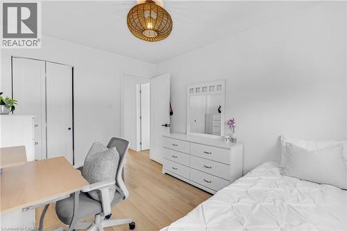 Bright room with wood-finish flooring and a decorative woven light fixture - 5275 Banting Court, Burlington, ON 