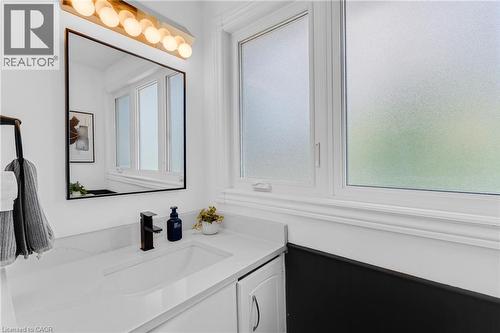 Modern vanity featuring an integrated sink, quartz countertop, and matte black faucet - 5275 Banting Court, Burlington, ON 