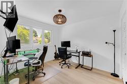 Bright room featuring wood-finish flooring, white walls, and a multi-pane window - 