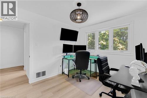 Bright room featuring wood-finish flooring, white walls, and a contemporary ceiling fixture - 5275 Banting Court, Burlington, ON 