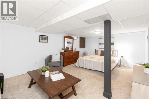 Carpeted room with a drop ceiling, white walls, and a dark support pillar - 5275 Banting Court, Burlington, ON 