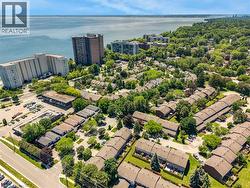Aerial perspective showcasing a residential community with abundant mature trees and proximity to a large body of water - 