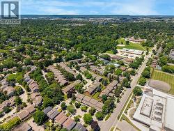 Aerial perspective showcasing an expansive residential area with abundant mature trees and varied housing styles - 