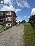Brick exterior apartment building featuring dark gray accent siding and multiple bay windows - 