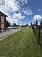 Expansive grass area with a chain-link fence border - 