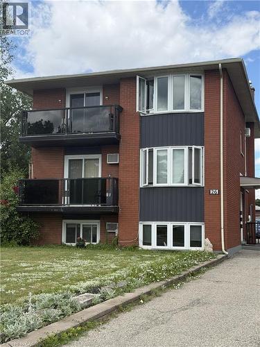 Brick multi-story building featuring two balconies with black railings and glass panels - 26 Carnaby Crescent, Kitchener, ON 