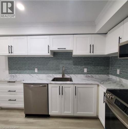 Contemporary kitchen featuring white cabinetry with matte black hardware, a stainless steel sink, and a stainless steel dishwasher - 59 Highgate Road Unit# 2, Kitchener, ON 