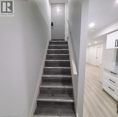 Staircase featuring wood-finish treads with white risers and handrail - 59 Highgate Road Unit# 2, Kitchener, ON 