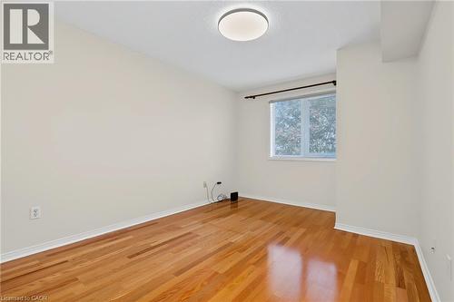 Bright room featuring wood-finish flooring, neutral wall paint, a single window, white baseboards, and a flush-mount ceiling light - 117 E Bristol Road E Unit# 64, Mississauga, ON 