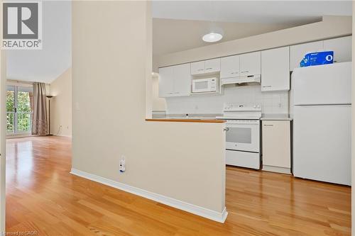 Kitchen featuring white cabinetry, white appliances, and a tile backsplash - 117 E Bristol Road E Unit# 64, Mississauga, ON 