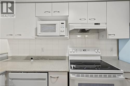 Kitchen featuring white cabinetry with silver-tone hardware, a tiled backsplash, and light-toned countertops - 117 E Bristol Road E Unit# 64, Mississauga, ON 