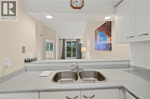 Kitchen pass-through featuring a double basin stainless steel sink and light-toned speckled countertops - 117 E Bristol Road E Unit# 64, Mississauga, ON 