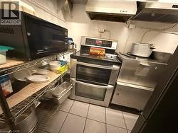 Functional kitchen space featuring a stainless steel double oven range, stainless steel vent hoods, and industrial-style wire shelving - 