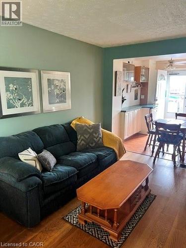 Living area featuring wood-finish flooring, a neutral wall color, and a partial archway leading to a dining space - 227 Fergus Avenue, Kitchener, ON 