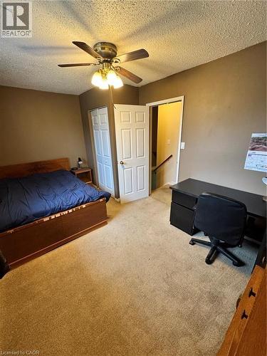 Carpeted room with a ceiling fan, a bi-fold closet door, and a traditional hinged door - 227 Fergus Avenue, Kitchener, ON 
