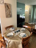 Dining area featuring wood-finish flooring, built-in lower cabinetry with dark countertops, and a ceiling fan - 