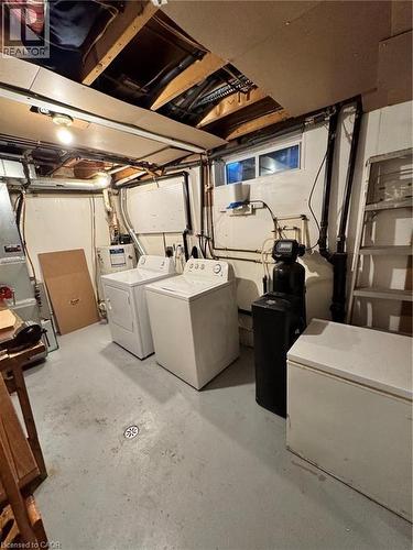 Laundry area featuring a concrete floor with a floor drain, exposed ceiling joists, and a partial finished ceiling - 227 Fergus Avenue, Kitchener, ON 