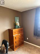 Living area featuring wood-finish flooring, a neutral wall color, and a partial archway leading to a dining space - 