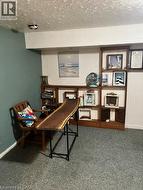 Laundry area featuring a concrete floor with a floor drain, exposed ceiling joists, and a partial finished ceiling - 
