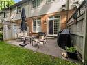 Paved patio area featuring a sliding glass door, a brick exterior, and a privacy fence - 120 Beddoe Drive Unit# 6, Hamilton, ON 