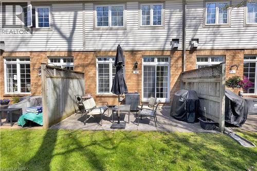 Exterior brick and siding facade with multiple white-framed windows and a sliding glass door - 120 Beddoe Drive Unit# 6, Hamilton, ON 
