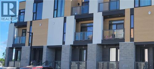 Modern multi-level exterior featuring light-toned siding, grey brick accents, and dark trim - 142 Foamflower Place Unit# 12, Waterloo, ON - Outdoor