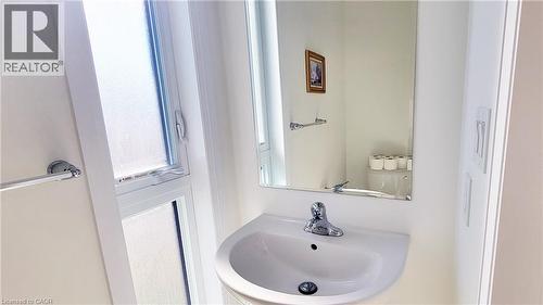 Pedestal sink with chrome faucet, wall-mounted mirror, and frosted window - 142 Foamflower Place Unit# 12, Waterloo, ON - Indoor Photo Showing Bathroom