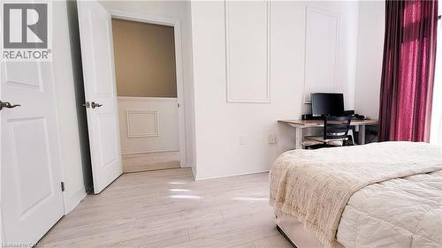 Light wood-finish flooring throughout, framed by white baseboards - 142 Foamflower Place Unit# 12, Waterloo, ON - Indoor Photo Showing Bedroom
