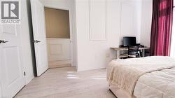 Light wood-finish flooring throughout, framed by white baseboards - 