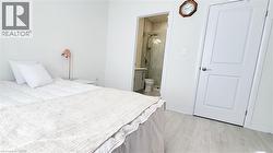 Bedroom featuring light wood-finish flooring and white walls - 