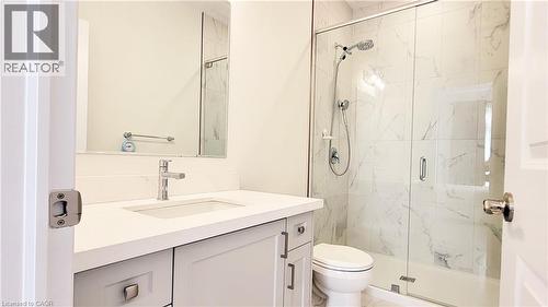 Bathroom featuring a frameless glass shower enclosure with white marble-style subway tile surround, a built-in shower niche, and a shower head with handheld sprayer - 142 Foamflower Place Unit# 12, Waterloo, ON - Indoor Photo Showing Bathroom