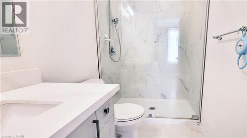 Contemporary bathroom featuring a spacious glass-enclosed shower, large format marble-look tile, and a floating vanity with a white countertop - 142 Foamflower Place Unit# 12, Waterloo, ON - Indoor Photo Showing Bathroom