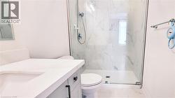 Contemporary bathroom featuring a spacious glass-enclosed shower, large format marble-look tile, and a floating vanity with a white countertop - 
