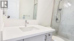 Modern bathroom featuring a single vanity with an undermount sink, a polished chrome faucet, and a large wall-mounted mirror - 