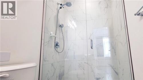 Walk-in shower featuring glass enclosure, white marble-look tile surround, dual shower heads, and chrome fixtures - 142 Foamflower Place Unit# 12, Waterloo, ON - Indoor Photo Showing Bathroom