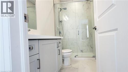 Modern bathroom featuring a white floating vanity with a light countertop, a glass-enclosed shower with white tiled walls, and coordinating floor tiling - 142 Foamflower Place Unit# 12, Waterloo, ON - Indoor Photo Showing Bathroom