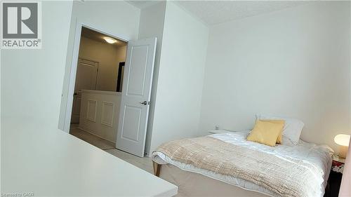 Clean bedroom space with light wood-finish flooring - 142 Foamflower Place Unit# 12, Waterloo, ON - Indoor Photo Showing Bedroom