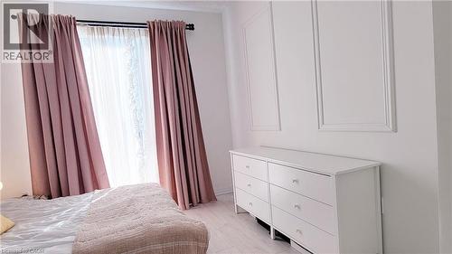 White wall paneling details complement the light wood-finish flooring - 142 Foamflower Place Unit# 12, Waterloo, ON - Indoor Photo Showing Bedroom
