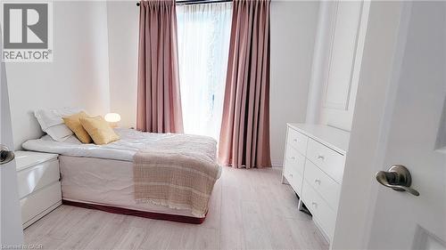 Light wood-finish flooring complements the neutral wall color - 142 Foamflower Place Unit# 12, Waterloo, ON - Indoor Photo Showing Bedroom